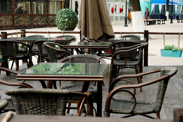 Székek és asztalok a nyári teraszon a szabadtéri kávézóban. - Fotó, kép