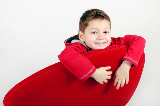 boldog fiú vörös szék - Fotó, kép