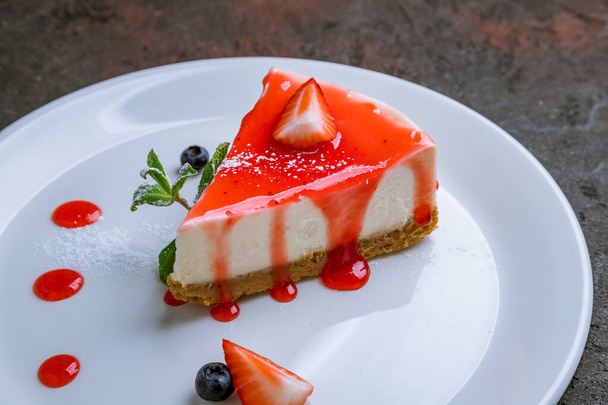 Classic cheesecake with strawberry and sause on white plate - Fotó, kép