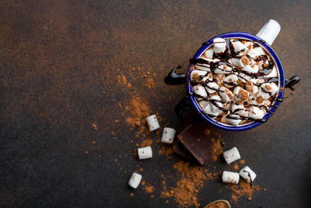 hot chocolate in an iron mug with marshmallow on dark rustic background. Copy space, top view - Foto, Imagem