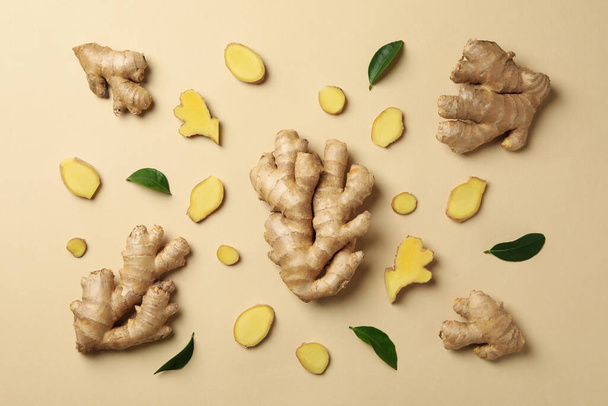 Fresh ginger and leaves on beige background, top view - Fotografie, Obrázek