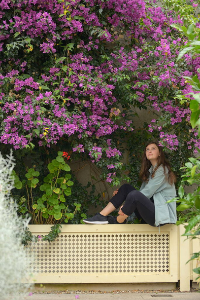 Young girl portrait and bougainvillea flowers in botanical garden - Foto, Imagen