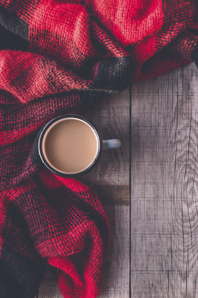 Tazza di caffè calda avvolta in una sciarpa per le giornate invernali con albero di Natale e presente su un tavolo di legno - Foto, immagini