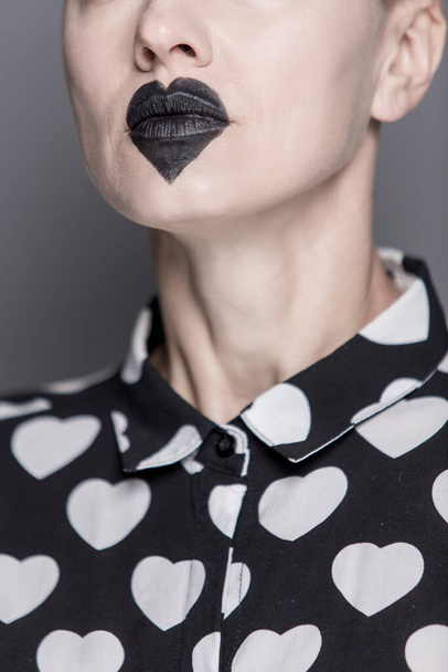 beautiful young woman with unusual make-up, black heart on lips. black and white - Фото, изображение