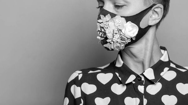 Woman in trendy fashion outfit during quarantine of coronavirus outbreak. Model dressed protective stylish handmade face mask on studio background - Foto, immagini
