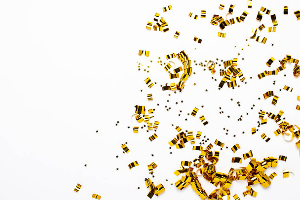 Golden confetti on a white background. The concept of a holiday, party, birthday, decoration. Banner Flat lay, top view. - Φωτογραφία, εικόνα