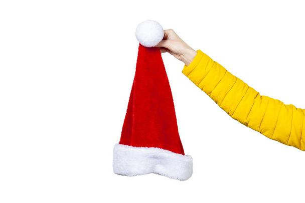 A mão feminina segura o chapéu de Papai Noel em um fundo branco. Conceito Natal, Ano Novo, celebração. - Foto, Imagem