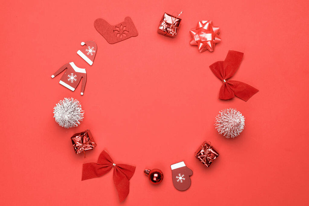Vánoční prodej. Punčochy, dárky, zimní strom, stuha a luk ve tvaru rámu na červeném pozadí pro pozdrav karty. Zimní slavnostní kompozice s kopírovacím prostorem - Fotografie, Obrázek