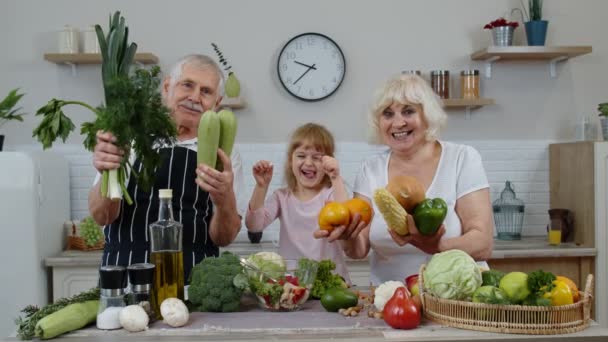 Nieta niña con abuelos mayores recomendando comer alimentos vegetales crudos. Dieta nutricional - Imágenes, Vídeo