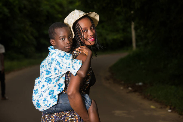 muotokuva nuori nainen kuljettaa poikaansa takana - Valokuva, kuva