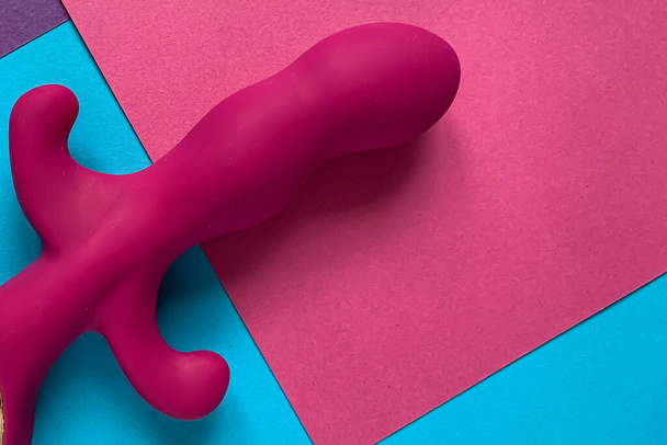 Seksilelu Vaaleanpunainen vibraattori vaaleanpunainen, sininen tausta. Hyödyllinen aikuisille, seksikauppa - Valokuva, kuva