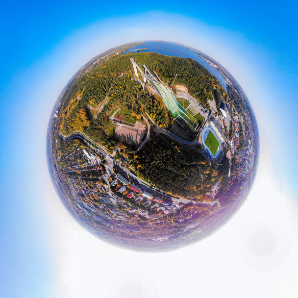 Trójwymiarowy panoramiczny widok z lotu ptaka na ośrodek sportowy Lahti z trzema wieżami do skoków narciarskich, w stylu panoramy mini planety. - Zdjęcie, obraz