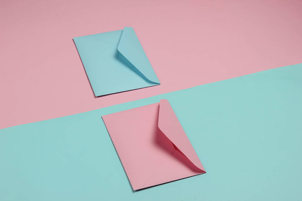 ピンクとブルーのパステルカラーの2つの封筒。バレンタインデー、結婚式や誕生日のためのモックアップ。トップ表示 - 写真・画像