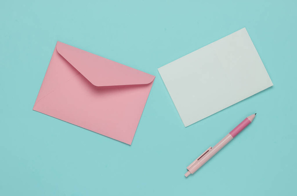 Envelope com uma carta e caneta em um fundo pastel azul. Dia dos Namorados, casamento ou aniversário. Vista superior - Foto, Imagem