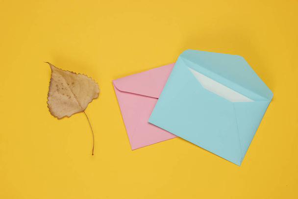 Zarfla zarf, sarı arka planda sonbahar yaprağı. Aşk mektubu mu? Üst görünüm - Fotoğraf, Görsel