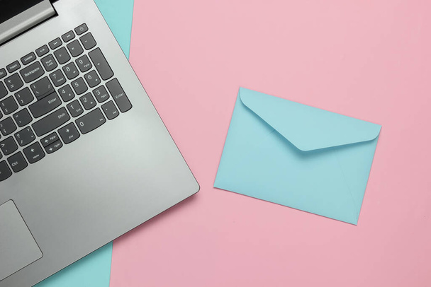 Laptop and envelope on pink blue pastel background. Valentine's day. Top view - Foto, Imagem