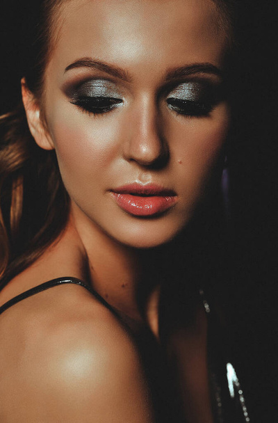 Beauty portrait of young woman with silver makeup. Perfect skin and evening makeup. Sensuality, passion, cosmetology, lip care, plastic surgery or injection concept. Vertical photo of girl with pure skin and silver smokey eyes.  - Фото, зображення