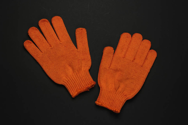Orange work gloves on black background. Top view - Photo, Image