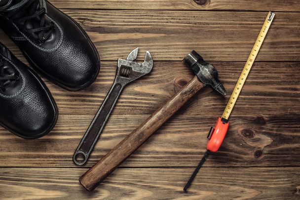 Composition à plat avec différents outils et instruments de travail industriels, équipement de sécurité sur fond en bois. Vue du dessus - Photo, image