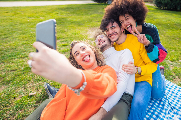 Wieloetniczni przyjaciele na świeżym powietrzu robiący selfie - Grupa różnorodnych przyjaciół bawiących się na świeżym powietrzu robiących na żywo w mediach społecznościowych - przyjaźń, vlogger, koncepcja komunikacji - Zdjęcie, obraz