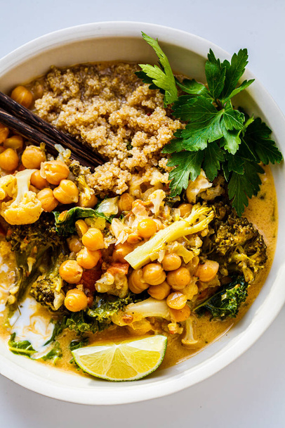 Vegan chickpea curry with cauliflower, broccoli, kale and quinoa. Healthy vegetarian food concept. - Foto, afbeelding