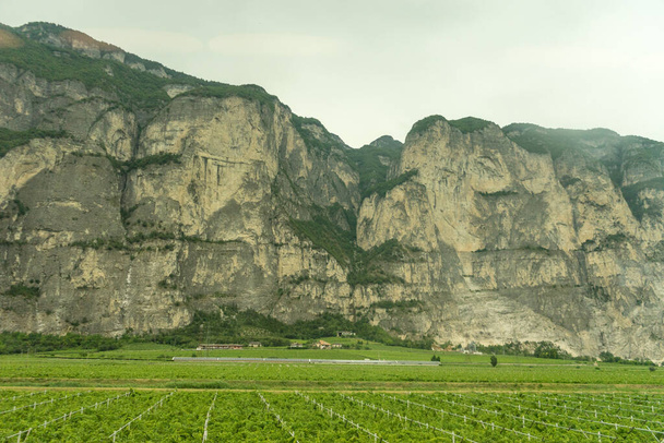 Европа, Италия, поезд Ла Фаста - Каслтелрут, большое зеленое поле с горой на заднем плане - Фото, изображение