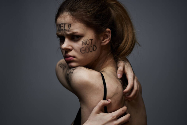woman with offensive inscriptions on her body touching herself with hands stress frustration hate - Foto, Bild