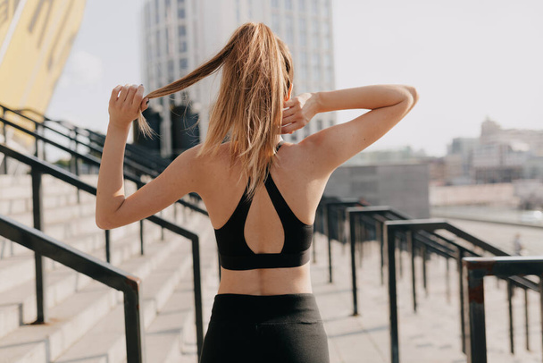Retrato de espalda de mujer atractiva en entrenamiento de ropa deportiva al aire libre. Deporte, footing, estilo de vida saludable y activo. Foto de alta calidad - Foto, imagen