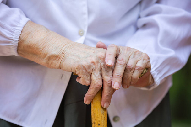 Las manos de una mujer mayor sosteniendo bastón - Foto, imagen