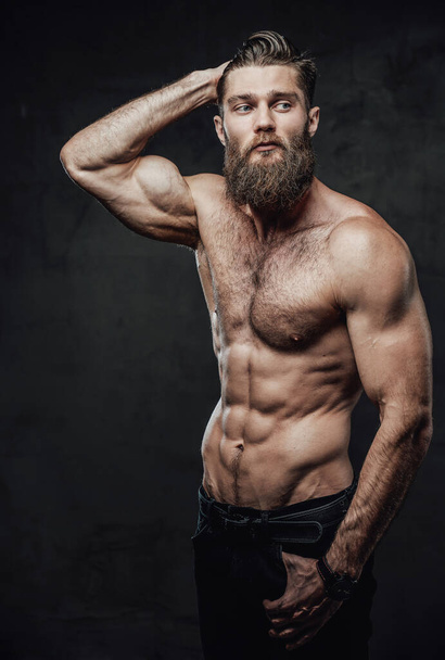 baard guy met naakt romp poseren in donker achtergrond - Foto, afbeelding