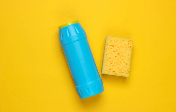 Ready for cleaning! Housework concept. Detergent bottle, sponge on a yellow background. Top view - Photo, Image