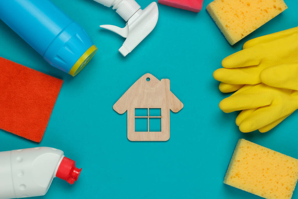 Housekeeping-Konzept. Set von Produkten für Reinigung und Hausfigur auf blauem Hintergrund. Ansicht von oben. - Foto, Bild