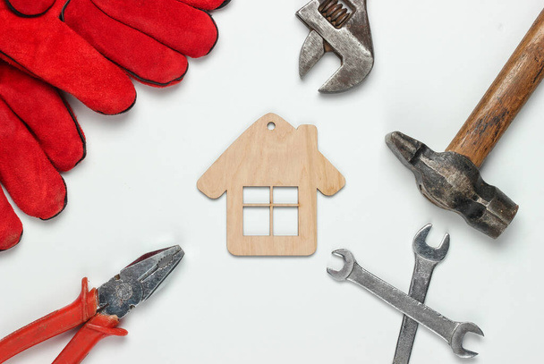 Comment construire une maison ? Outils de bricolage et mini figurine de maison sur fond blanc - Photo, image