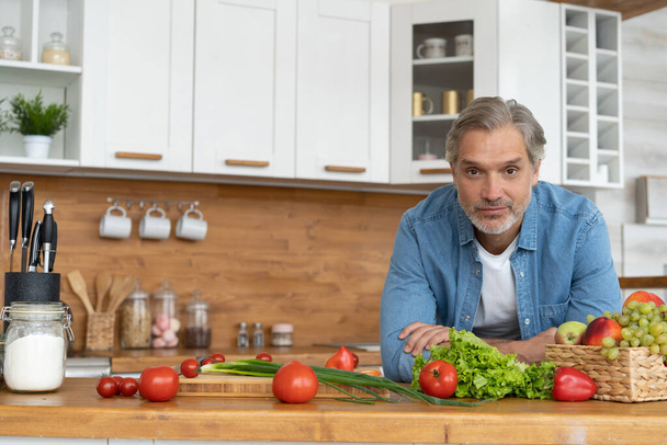 Grey-haired Mature handsome caucasian man standing in the bright kitchen - Foto, Imagem
