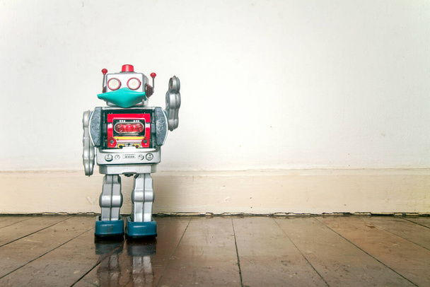 giocattolo robot retrò con una maschera su un vecchio pavimento in legno con copyspace  - Foto, immagini