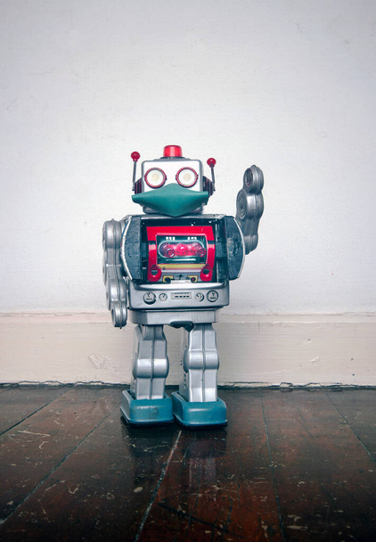 retro robot toy  with a mask on a old wooden floor with copyspace  - Photo, Image