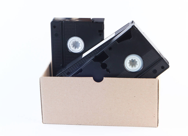 Cardboard box with video cassettes on a white background - Photo, Image