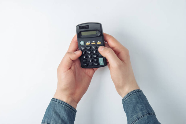 Male hands count on a calculator on white background - Foto, immagini