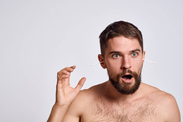 Бородатый мужчина с голыми плечами хлопок-тампоны гигиенические средства ухода за телом - Фото, изображение