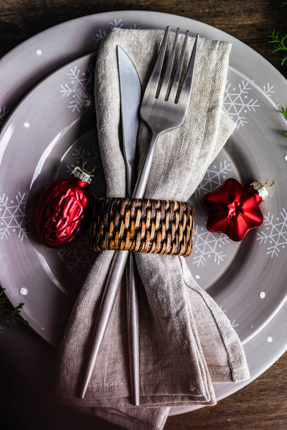 Lege bord met feestelijke inrichting en bestek op tafel voor kerstdiner - Foto, afbeelding