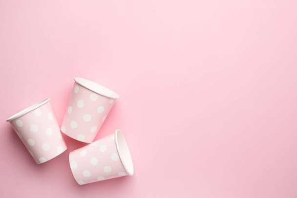 Pink in polka dot cardboard cups, eco dishes and conscious consumption with copyspace top view - 写真・画像