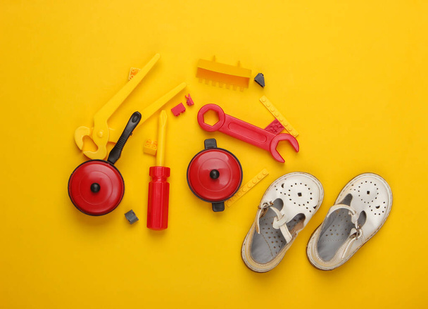 composição de leigos planos de sandálias infantis e brinquedos no fundo amarelo. Vista superior - Foto, Imagem