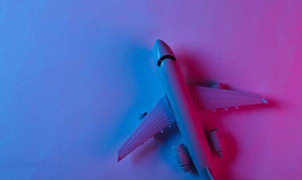 Neon mavi-pembe ışıklı bir uçak figürü. Üst görünüm - Fotoğraf, Görsel
