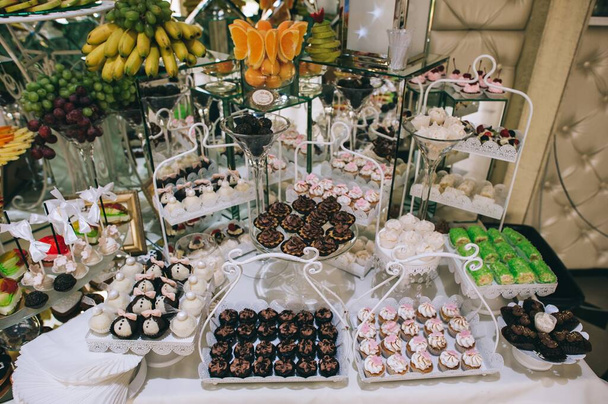 Various colored delicious sweets in a candy bar at a wedding. Sweet table. Wedding buffet. - Foto, Bild