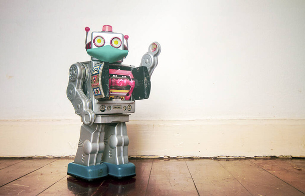 retro robot toy  with a mask on a old wooden floor with copyspace - Photo, Image