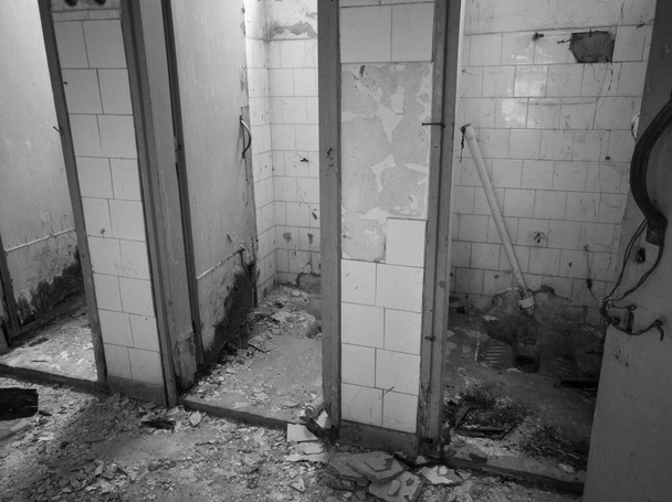 Sisätilojen vanha sotkuinen hylätty ja pilalla WC mökkejä, rikki ovet ja puuttuvat saniteettitavarat - Valokuva, kuva
