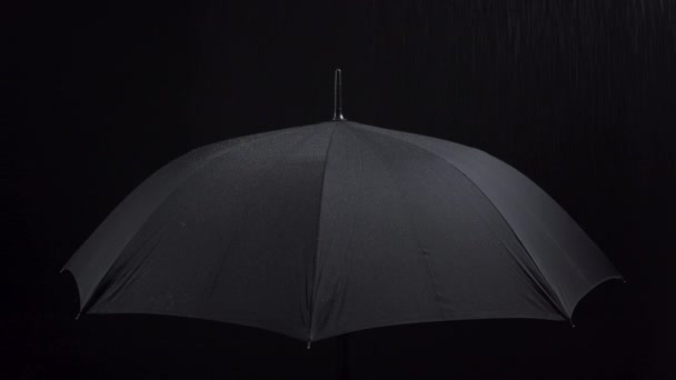 Video van paraplu en regendruppels op zwarte achtergrond - Video