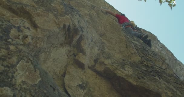 Joven escalador descansando en medio de las rocas - Imágenes, Vídeo