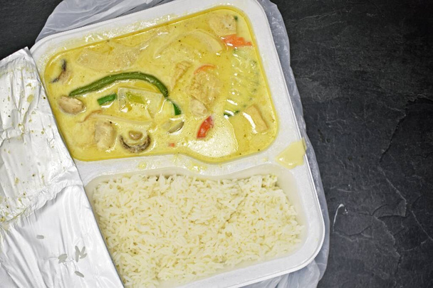 Chińskie curry z ryżem w polistyrenowym pudełku, jak zabrać jedzenie - zbliżenie na zielone curry z ryżem w szkodliwym dla środowiska plastikowym pudełku - zabrać lunch, w biurze - Zdjęcie, obraz
