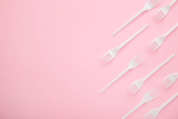 Many plastic forks on a pink background. Top view. - Foto, Imagen